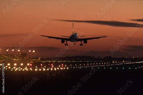 Airplane silhouette landing at the airport during sunser, Barcelona