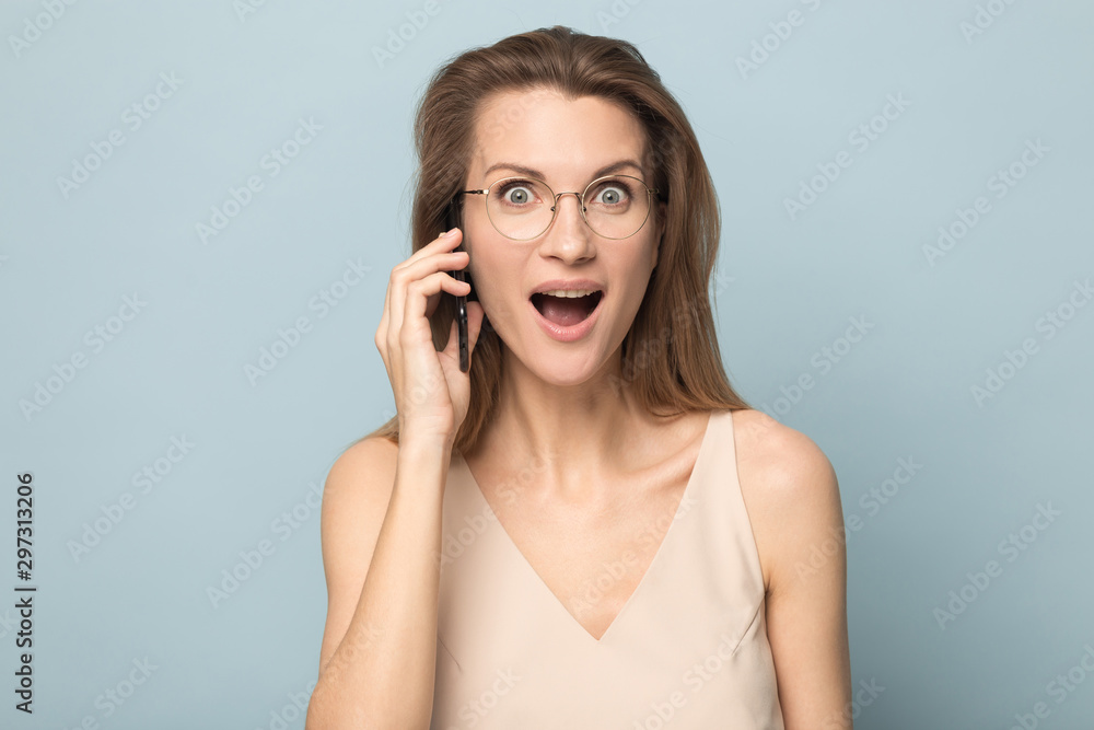 Amazed millennial woman shocked by unexpected news on cell Amazed millennial woman shocked by unexpected news on cell