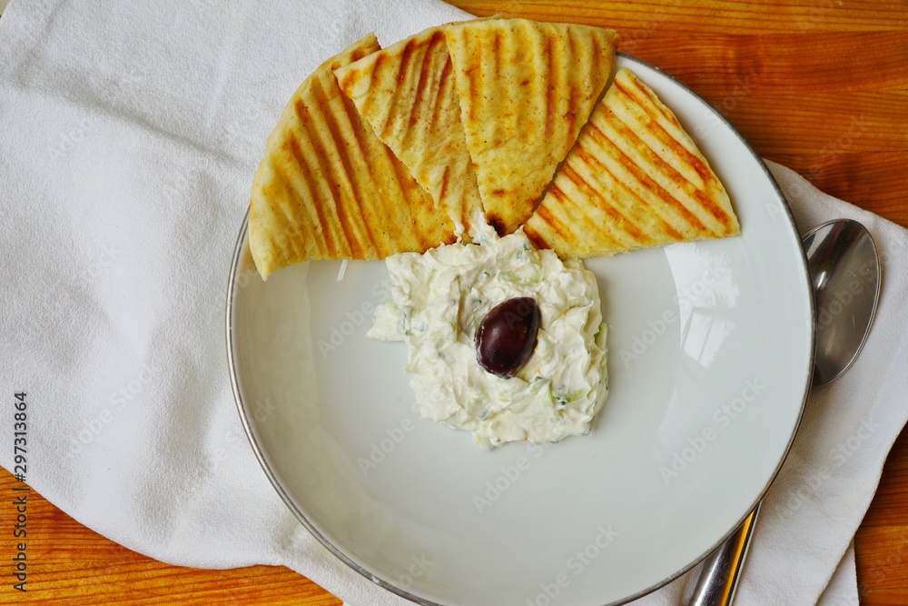 Obraz premium Greek tzatziki yogurt dip with grilled pita bread