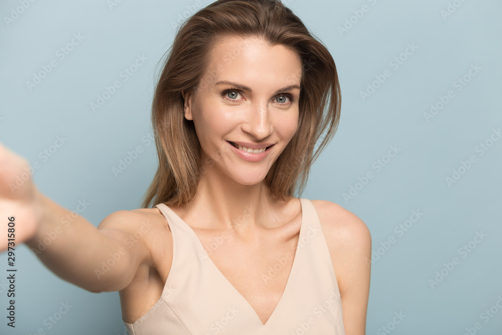 Smiling millennial woman making self-portrait picture in studio Smiling millennial woman making self-portrait picture in studio