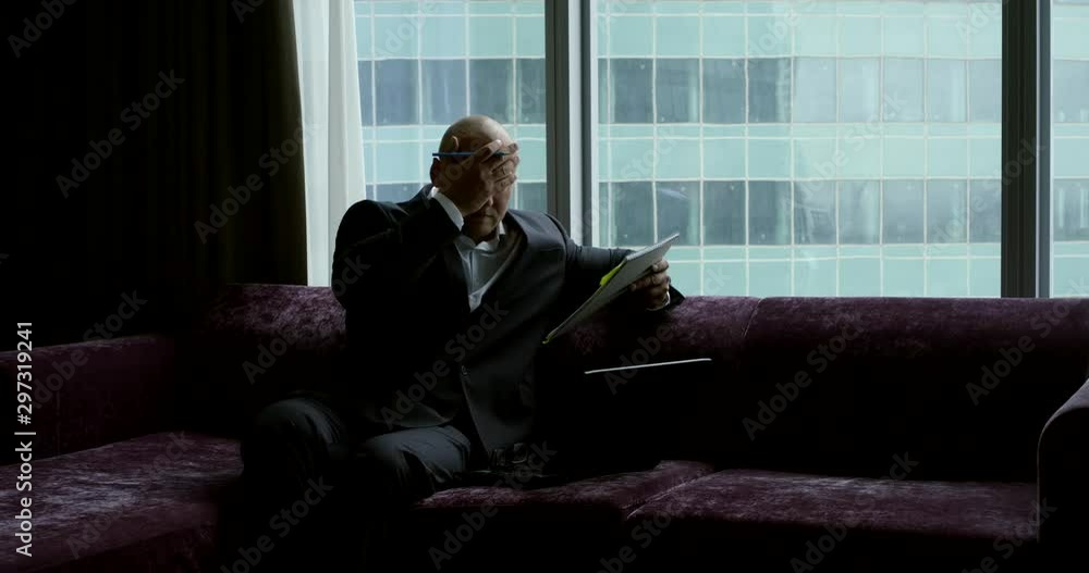 upset businessman with papers on sofa in office slow motion upset businessman with papers on sofa in office slow motion