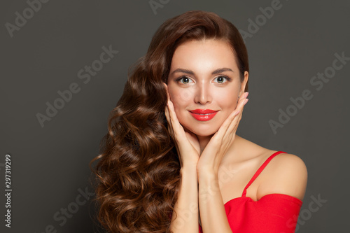 Beautiful woman portrait. Perfect model with long healthy brown curly hair and red lips makeup