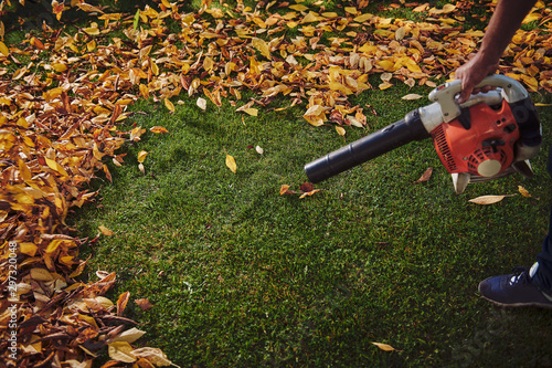 A man working with a leaf blower photo