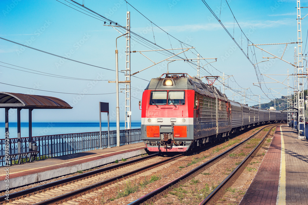 Passenger train moves along the platform by Black sea coast. Sochi. Passenger train moves along the platform by Black sea coast. Sochi.