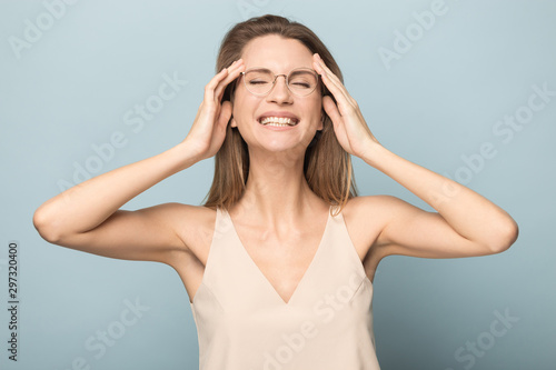 Overjoyed millennial woman in glasses laughing in studio