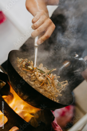 A caucasian man cooking street food in a food truck. Wok. Selective Focus