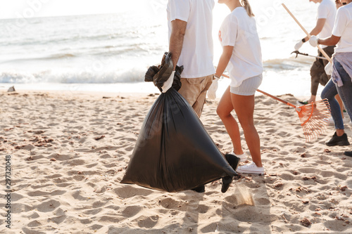 Photo of volunteers cleaning beach from plastic with trash bags