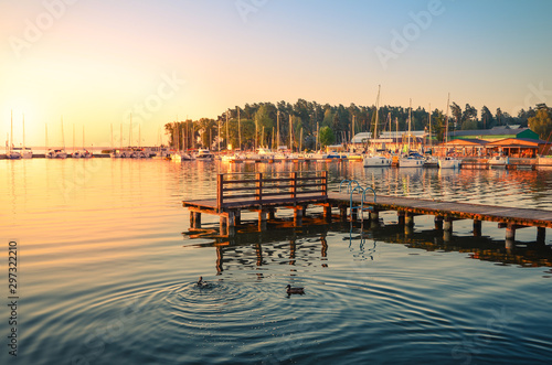 Boats docking in the marina at the Niegocin Lake during sunrise.. Wilkasy, Masuria , Poland.