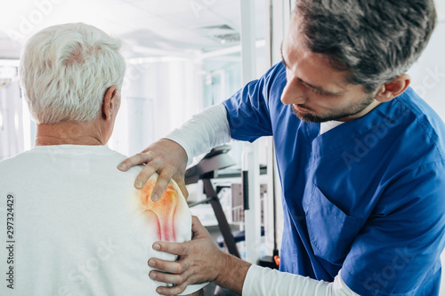 physiotherapist examines a patient with arthritis of the shoulder joint. photo