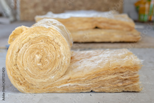 Mineral rockwool lying on attic floor inside house under construction