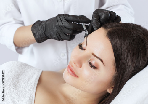 The doctor cosmetologist makes the Rejuvenating injections procedure for tightening and smoothing wrinkles on the face skin of a beautiful woman in a beauty salon.Cosmetology skin care.