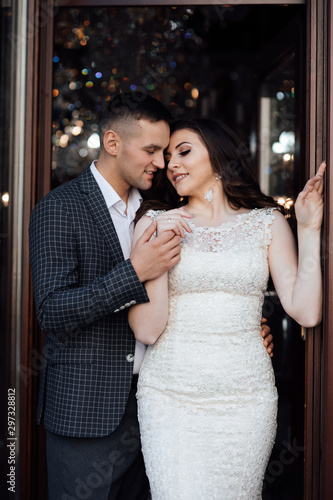 Handsome guy in suit and girl in white dress. Fashionable photo of young people. Romantic youth concept. Young stylish couple pose. Love and tenderness. Happy lovers and family. 