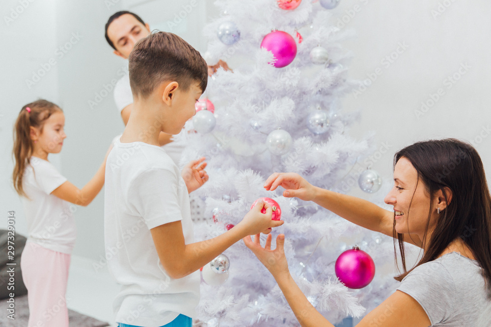 family, x-mas, winter holidays and people concept - happy mother, father and little daughter with son decorating christmas tree at home family, x-mas, winter holidays and people concept - happy mother, father and little daughter with son decorating christmas tree at home