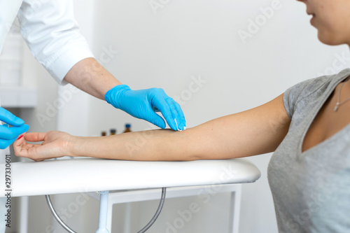 A nurse wipes a patients hand with a cotton pad soaked in an antiseptic. Blood sampling procedure