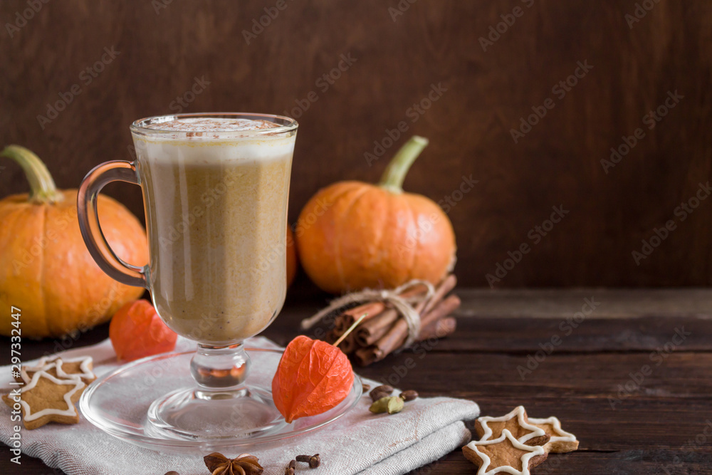 Pumpkin smoothie latte with spices in a tall glass on a wooden background in a rustic style. Autumn mood. Cookies, pumpkin, cinnamon, spices. Copy space, close-up, side view. Pumpkin smoothie latte with spices in a tall glass on a wooden background in a rustic style. Autumn mood. Cookies, pumpkin, cinnamon, spices. Copy space, close-up, side view.
