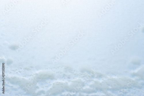 Abstract winter background, frozen glass covered with snow.
