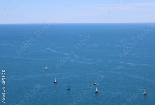 Regata di sei barche a vela con orizzonte marino