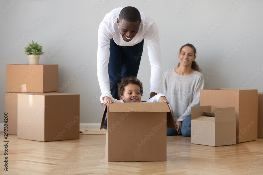 Happy african American dad playing with son on moving day Happy african American dad playing with son on moving day