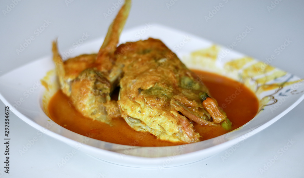 Snapper head gulai (curry) on white background. Gulai is type of food containing rich, spicy and succulent curry. Snapper head gulai (curry) on white background. Gulai is type of food containing rich, spicy and succulent curry.