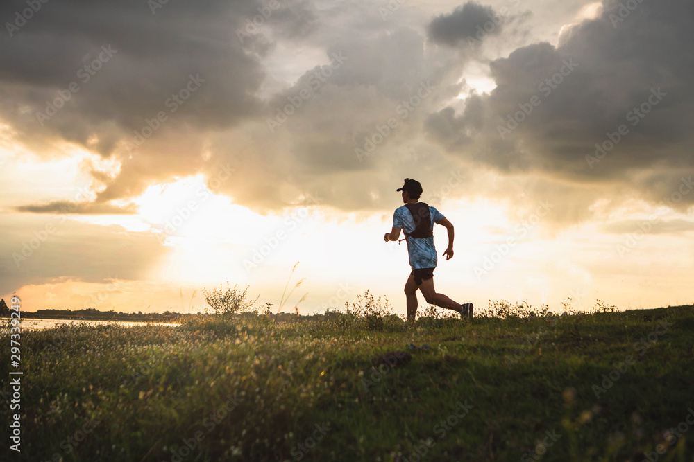 Outdoor trail running in early sunrise concept for exercising, fitness and healthy lifestyle. Young people running on country trail path. Soft focus. Outdoor trail running in early sunrise concept for exercising, fitness and healthy lifestyle. Young people running on country trail path. Soft focus.