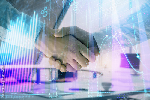 Multi exposure of financial graph on office background with two businessmen handshake. Concept of success in business © Andrey