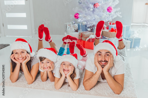 happy family lies on the floor near the festive Christmas tree, near Christmas gifts
