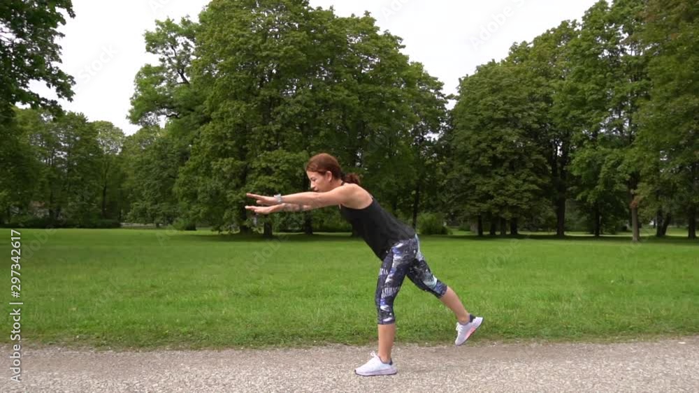 slow motions-young sporty woman exercisisng in green park before jogging slow motions-young sporty woman exercisisng in green park before jogging