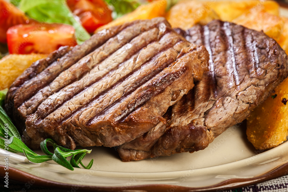 Succulent portions of grilled fillet mignon served with baked potatoes Succulent portions of grilled fillet mignon served with baked potatoes