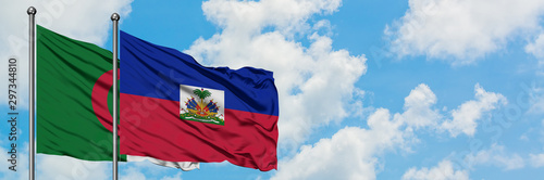 Φωτογραφία Algeria and Haiti flag waving in the wind against white cloudy blue sky together