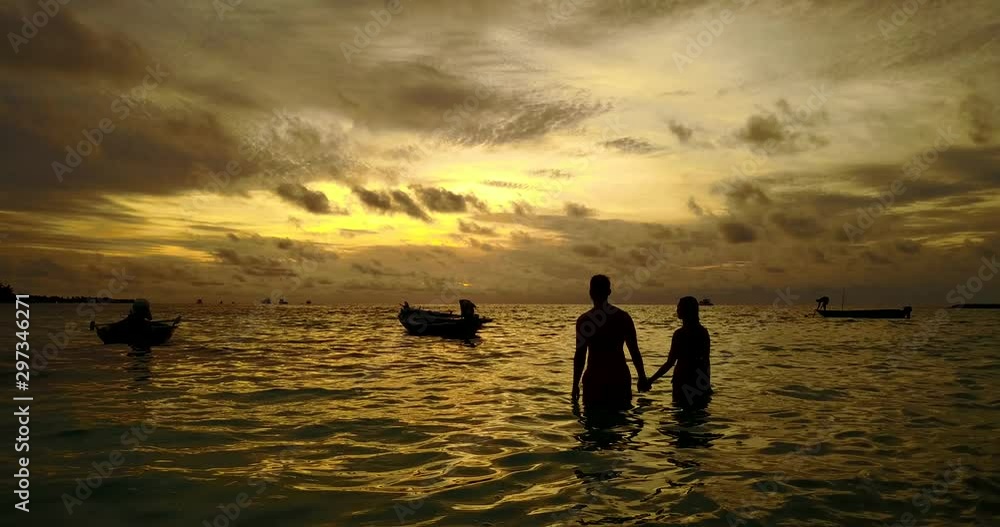 Young couple watch the sunset in the ocean Young couple watch the sunset in the ocean
