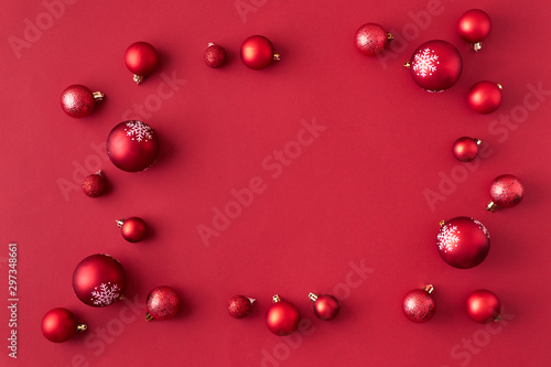 Flat lay frame with red christmas balls on a red background
