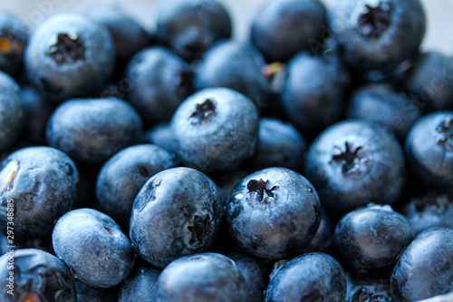 Background with fresh blueberries closeup. Blueberry macro photography. Organic berries of bright blue color. Template for banner, menu, food label, organic shop, garden harvesting. Healthy eating