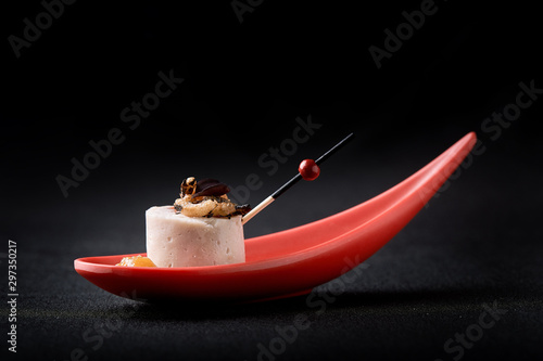 Goose liver pate, foie gras, served on black stone in Japanese red spoons. Paste served with jam and nuts. Fusion food concept, low key, copy space.
