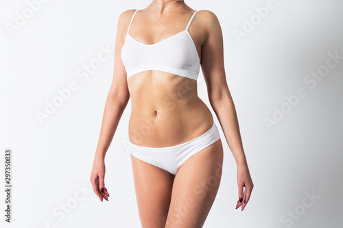 Slim figure of a woman in underwear on white background.