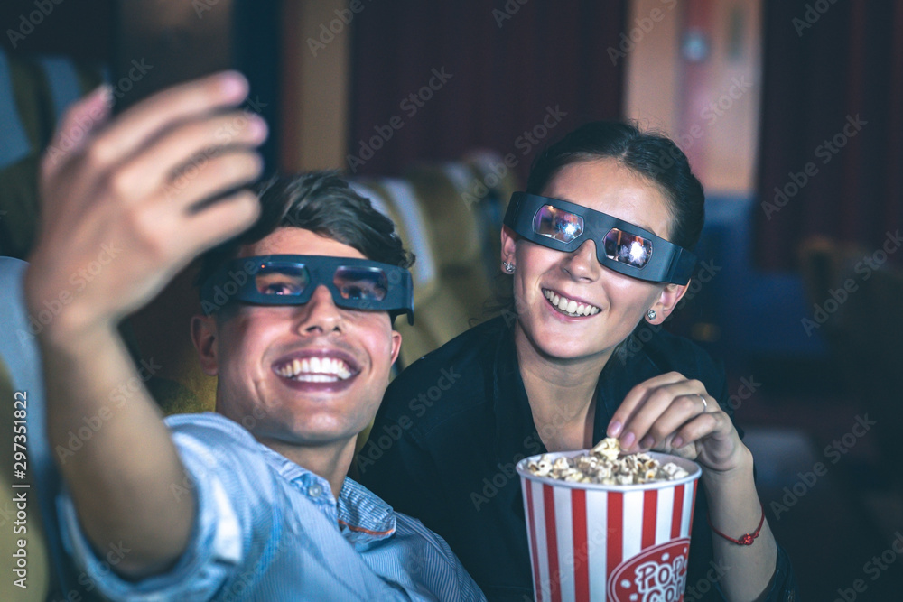 Obraz premium Couple taking a selfie in a cinema wearing 3d glasses.