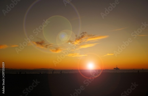 Beach sunset with bright sun and lens flares