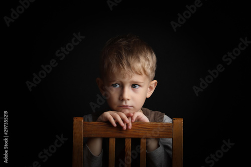 little blond boy 3-4 years old with sincere emotion. Background shot in studio with soft lights with an interesting expression and dramatic.