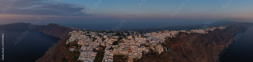 Fototapeta premium Aerial drone photo of beautiful sunset over picturesque village of Imerovigli and Skaros rock with beautiful golden colours, Santorini island, Cyclades, Greece