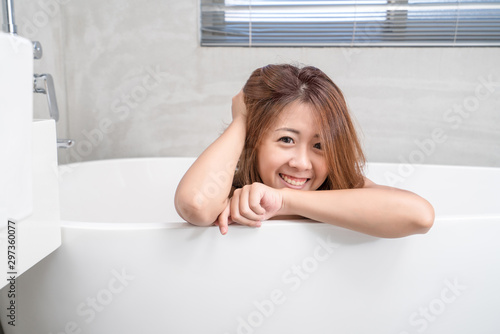 Portrait of young attractive asian girl takes a bath with candles relax in the bathroom. Beauty woman in spa treatments. Healthy perfect glow skin care concept