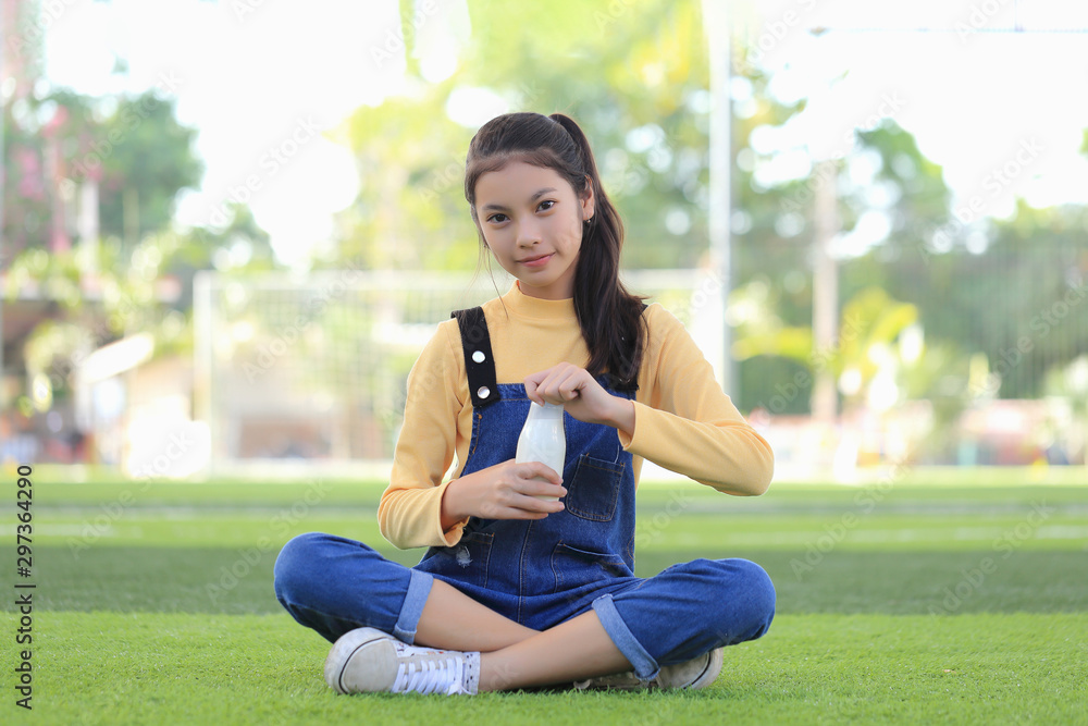 An Asian girl is drinking a delicious bottle of milk. An Asian girl is drinking a delicious bottle of milk.