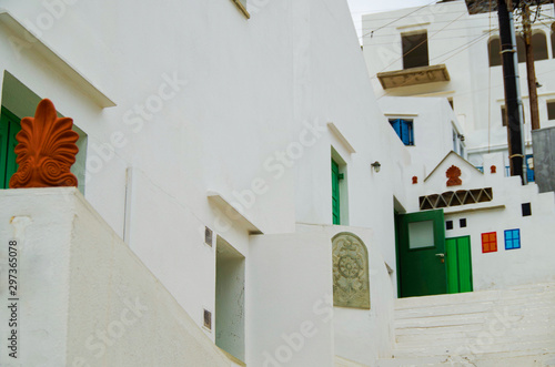 White stairs in romantic backstreet alley lane alleyway street with traditional typical Greek white buildings and colorful blue white buildings and balconies on Sifnos in Greece photo