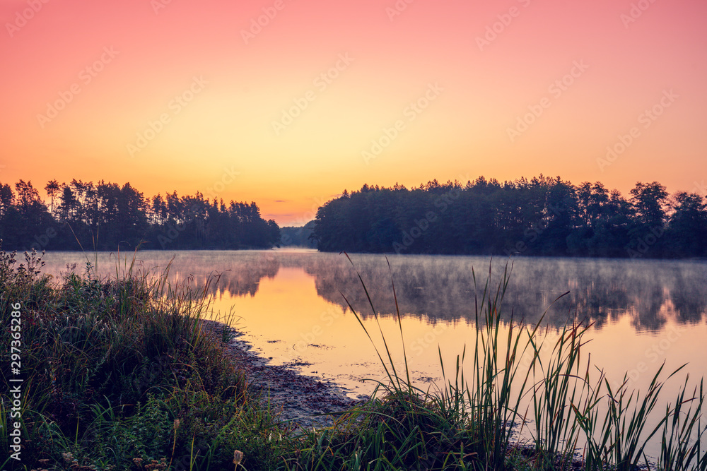 Magical dawn over the lake with a beautiful reflection on the water. Serene lake in the early morning. Nature landscape