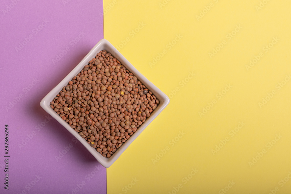 Lentils in a white ceramic bowl, on colored cardboards Lentils in a white ceramic bowl, on colored cardboards