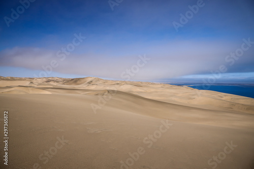 Dune de sable jaune dominant l'océan Atlantique en Namibie - Afrique