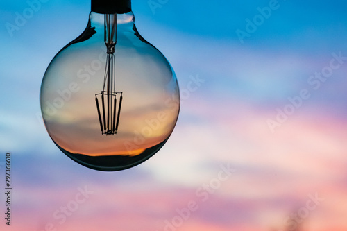 Beautiful defocused sunset in a light bulb. Sunset or sunrise background. Electricity concept. Earth hour. Energy consumption and environmental conservation, energy saving