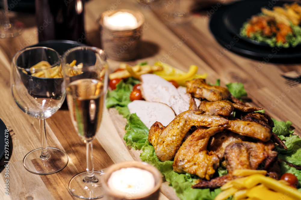 Festive table setting. Food and drinks, plates and glasses. Evening lights and candles. New Year's Eve. Festive table setting. Food and drinks, plates and glasses. Evening lights and candles. New Year's Eve.