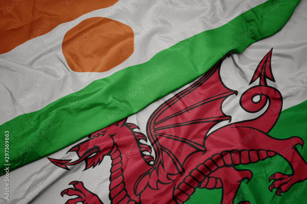 waving colorful flag of wales and national flag of niger.