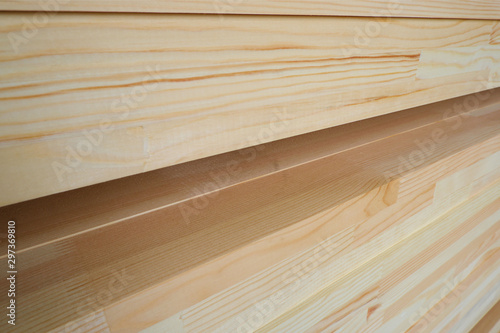 Side view of stack of three-layer wooden glued laminated timber beams from pine finger joint spliced boards