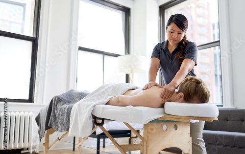 Cuadro en lienzo Chinese woman massage therapist giving a treatment to an attract