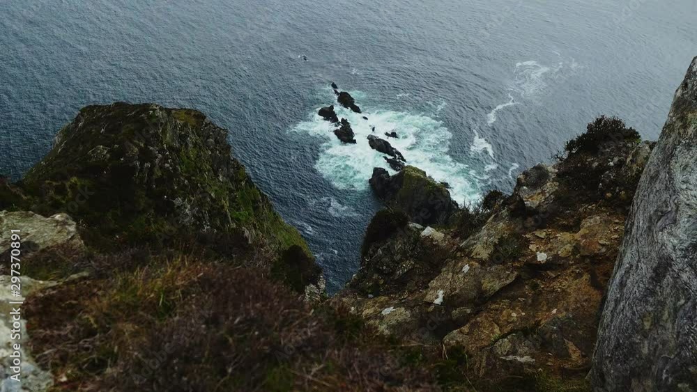 View from over a cliff of the sea waves breaking on the rocks. SLOW MOTION View from over a cliff of the sea waves breaking on the rocks. SLOW MOTION